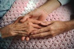 elderly resident holding hands with young care worker